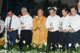 Các đại biểu dành một phút mặc niệm tưởng nhớ nạn nhân mất vì Covid-19. Ảnh: Hoàng Hùng/SGGP