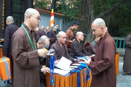 Giới tử trình giấy báo trúng tuyển và nhận thẻ đeo trước khi nhập chúng Giới đài viện Huệ Nghiêm - Quảng Hậu/BGN