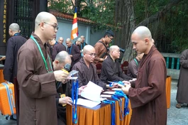 Giới tử trình giấy báo trúng tuyển và nhận thẻ đeo trước khi nhập chúng Giới đài viện Huệ Nghiêm - Quảng Hậu/BGN