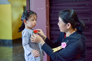 Một em bé tham dự lễ Vu lan - Báo hiếu tại tu viện Vĩnh Đức được mẹ cài lên ngực đóa hoa hồng tươi thắm - Ảnh: Quảng Đạo/BGN