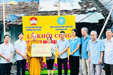 Đại đức Thích Nguyên Bảo trao bảng tượng trưng số tiền 80 triệu đồng hỗ trợ xây dựng nhà Đại đoàn kết cho hộ gia đình khó khăn 