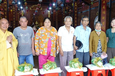 Thượng tọa Thích Minh Sơn, trụ trì chùa Linh Phước và bà Mai Thị Luyến, Chủ tịch Ủy ban MTTQVN xã Tân Phú Trung tặng quà đến bà con có hoàn cảnh khó khăn