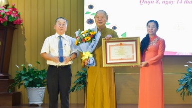 Bà Phan Kiều Thanh Hương, Phó Giám đốc Sở Nội vụ TP.HCM và ông Võ Ngọc Quốc Thuận, Bí thư Quận ủy Q.8 trao Bằng khen của Thủ tướng Chính phủ đến Thượng tọa Thích Huệ Công