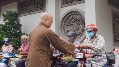 Đại đức Thích Minh Đạo, trụ trì chùa Nam Thiên Nhất Trụ trao quà đến người dân lao động khó khăn