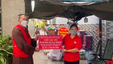 Thượng tọa Thích Lệ Quang trao quà đến đại diện Hội Chữ thập đỏ để tặng những gia đình khó khăn 