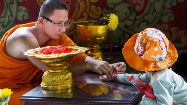 Vị sư buộc chỉ tay cho một em bé, cầu chúc may mắn trong năm mới