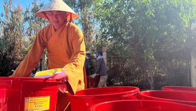 Đại đức Thích Minh Phú chuẩn bị thùng chứa nước tặng đến bà con xã Long Hựu Đông