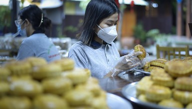 Một bạn trẻ đang kiểm tra bánh trung thu trước khi cho vào túi ni-lon bảo quản