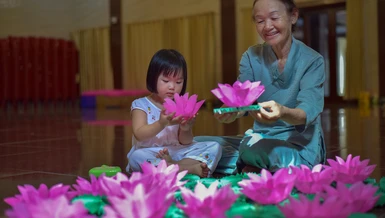 Hai bà cháu tham gia làm hoa đăng tại Việt Nam Quốc Tự - Ảnh: Quảng Đạo/BGN