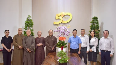 Ông Lê Văn Minh tặng hoa chúc mừng của Ban Tuyên giáo và Dân vận Thành ủy TP.HCM đến Thượng tọa Thích Tâm Hải nhân dịp Kỷ niệm 50 năm ngày Báo Giác Ngộ ra số đầu tiên (1-1-1976 – 1-1-2026) - Ảnh: Quảng Đạo/BGN