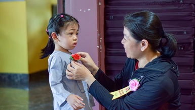 Một em bé tham dự lễ Vu lan - Báo hiếu tại tu viện Vĩnh Đức được mẹ cài lên ngực đóa hoa hồng tươi thắm - Ảnh: Quảng Đạo/BGN