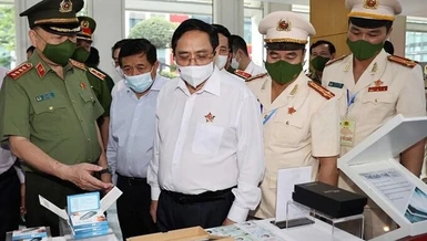 Thủ tướng Phạm Minh Chính tham quan trưng bày các trang thiết bị phục vụ dự án Cơ sở dữ liệu quốc gia về dân cư - Ảnh: TTX
