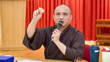 Thượng tọa Thích Tâm Hải giới thiệu biểu trưng (logo) chính thức của sự kiện Kỷ niệm 50 năm Báo Giác Ngộ ra số đầu tiên qua sản phẩm pin - Ảnh: Quảng Đạo/BGN