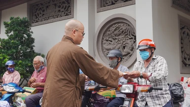 Đại đức Thích Minh Đạo, trụ trì chùa Nam Thiên Nhất Trụ trao quà đến người dân lao động khó khăn