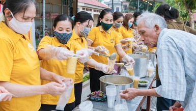 Các tình nguyện viên trao suất cháo đến bệnh nhân nghèo