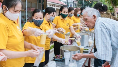 Các tình nguyện viên trao suất cháo đến bệnh nhân nghèo