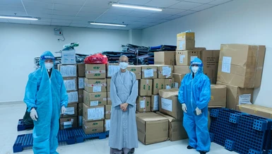 Bác sĩ Phạm Đăng Trọng Tường (bìa trái) tiếp nhận quà từ Sư cô Thích nữ Nhuận Bình đại diện nhóm tình nguyện viên Phật giáo trao tặng