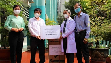 Nhà báo Trần Trọng Dũng trao 100 triệu đồng đến Giám đốc Bệnh viện Nguyễn Tri Phương Võ Đức Chiến - Ảnh: HNB TP