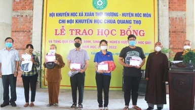 Thượng tọa Thích Lệ Tâm và ông Đỗ Trung Tín trao học bổng đến các em mồ côi - Ảnh: CTV