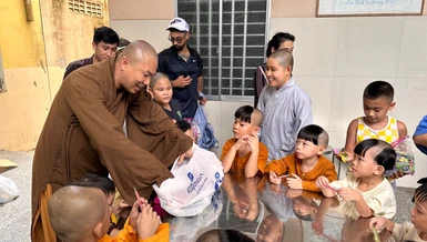  Đại đức Thích Minh Phú trao quà cho trẻ em mồ côi đang được nuôi dưỡng tại chùa Phật Minh, xã Giao Long