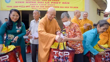 Hòa thượng Thích Lệ Trang, Trưởng ban Trị sự GHPGVN TP.HCM và bà Trần Kim Yến, Chủ tịch Ủy ban MTTQVN TP.HCM trao quà từ thiện đến bà con nghèo trên bàn quận 10 - Ảnh: B.Toàn/BGN