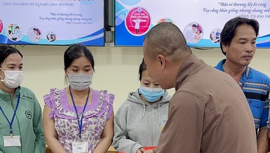 Đại đức Thích Minh Phú trao quà đến gia đình các cháu bệnh nhi tại Bệnh viện Nhi Đồng 1 - Ảnh: TN