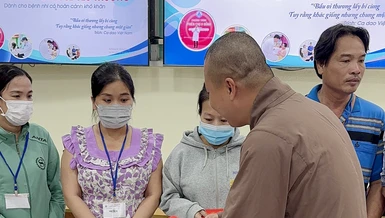 Đại đức Thích Minh Phú trao quà đến gia đình các cháu bệnh nhi tại Bệnh viện Nhi Đồng 1 - Ảnh: TN