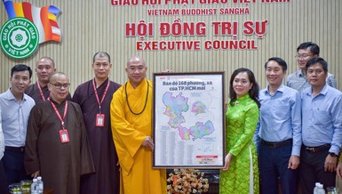 Bà Nguyễn Thanh Xuân tặng bản đồ 168 phường - xã TP.HCM đến Thượng tọa Thích Phước Nguyên - Ảnh: Quảng Đạo/BGN