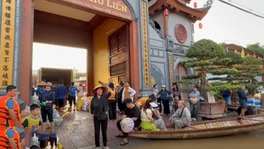 Bà con Phật tử chùa Phù Liễn dùng xuồng chở lương thực, thực phẩm đến tiếp tế bà con vùng ngập nặng tại tỉnh Thái Nguyên - Ảnh: PGTN