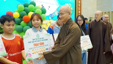 Thượng tọa Thích Thiện Quý trao quà cho các em học sinh khó khăn - Ảnh: H.D