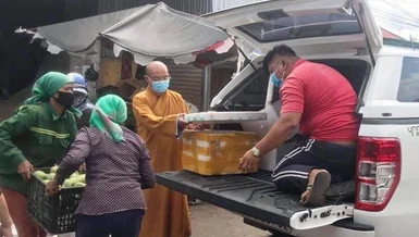 Đại đức Thích Nhuận Độ cùng bà con Phật tử người đồng bào đóng thùng rau củ gửi đến Sài Gòn - Ảnh: NA