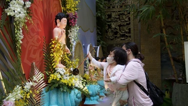 Em theo mẹ về chùa làm lễ Tắm Phật tại tôn tượng Phật đản sanh chùa Giác Ngộ, quận 10, TP.HCM