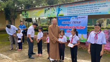 Thượng toạ Thích Quảng Tuấn, trụ trì chùa Hoa Nghiêm, cùng đoàn trao các suất học bổng đến các em học sinh