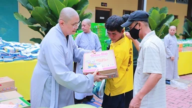 Ni sư Thích Chúc Tường, Phó Trưởng ban Thường trực Phân ban Ni giới TP.Thủ Đức, trụ trì chùa Kiều Đàm trao quà đến người dân - Ảnh: Trung Thắng