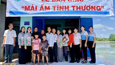 Đoàn dâng hoa Hữu Thiện bàn giao mái ấm tình thương đến gia đình bà Nguyễn Thị Thôi - Ảnh: D.H.H.T