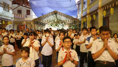Các em học sinh cùng nhau thực hiện nghi thức niệm Phật, mở đầu cho chương trình 'Em hướng về Vesak", tại chùa Long Vân - Ảnh: H.Y