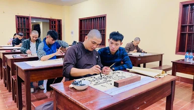 Bạn trẻ đang được thầy hướng dẫn cách viết thư pháp