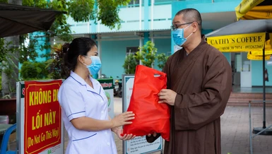 Đại đức Thích Minh Thuận đại diện Quỹ Đến Từ Trái Tim tặng quà lực lượng bảo vệ chốt chống dịch và y tế tại các nơi cách ly trên địa bàn quận Tân Phú.