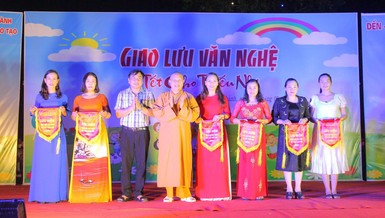Thượng tọa Thích Thông Kiên và lãnh đạo huyện Yên Thành tặng cờ lưu niệm cho các đơn vị trường học tham dự chương trình văn nghệ