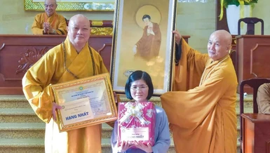 Hòa thượng Thích Lệ Trang, Trưởng ban Trị sự GHPGVN TP.HCM trao giải nhất và Thượng tọa Thích Giác Dũng, Thư ký Văn phòng Đức Pháp chủ trao quà đặc biệt của Đức Pháp chủ GHPGVN đến Phật tử Liên Loan - Ảnh: Quảng Đạo/BGN