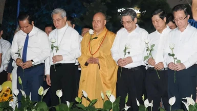 Các đại biểu dành một phút mặc niệm tưởng nhớ nạn nhân mất vì Covid-19. Ảnh: Hoàng Hùng/SGGP