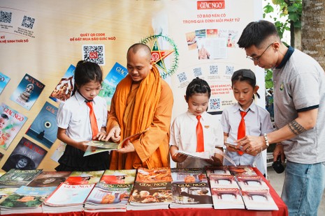 Các em nhỏ tìm hiểu Phật pháp bên những ấn phẩm Báo Giác Ngộ được trưng bày trong khuôn viên tịnh xá Ngọc Thạnh - Ảnh: Đức Huy