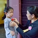 Một em bé tham dự lễ Vu lan - Báo hiếu tại tu viện Vĩnh Đức được mẹ cài lên ngực đóa hoa hồng tươi thắm - Ảnh: Quảng Đạo/BGN