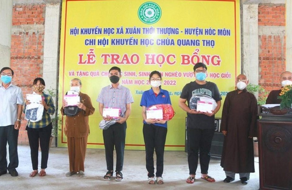 Thượng tọa Thích Lệ Tâm và ông Đỗ Trung Tín trao học bổng đến các em mồ côi - Ảnh: CTV