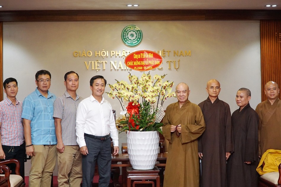 Đại tá Bùi Công Tú và thành viên đoàn tặng hoa chúc mừng chư tôn đức Ban Trị sự TP.HCM
