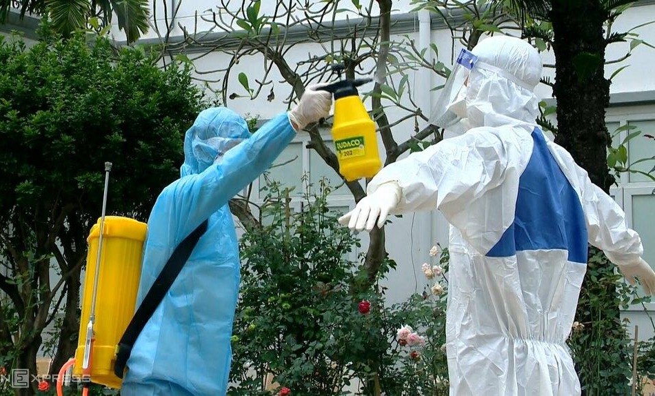 Nhân viên y tế phun khử khuẩn trước khi tiến hành lấy mẫu xét nghiệm. Ảnh: Thế Quỳnh.