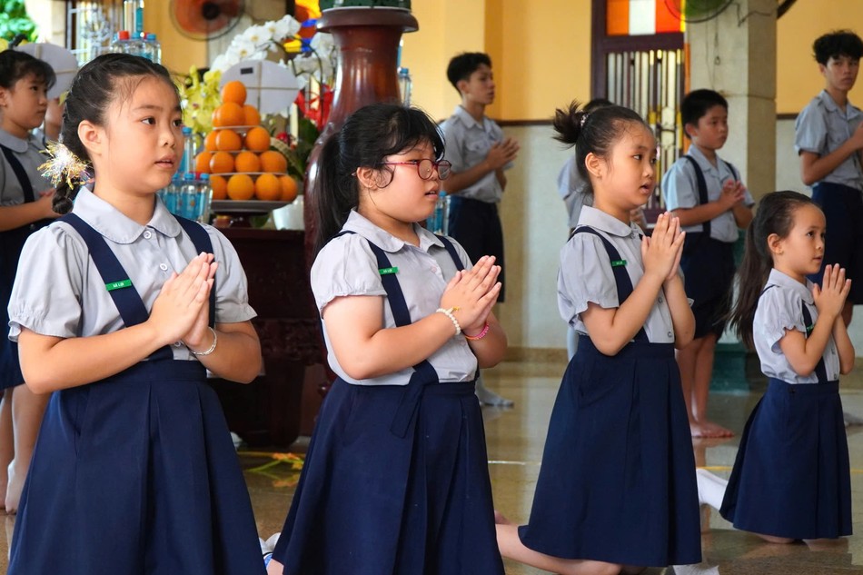 Ý Lạc (thứ hai từ trái qua) cùng các bạn đoàn sinh Gia đình Phật tử tụng kinh tại chùa Xá Lợi - Ảnh: Như Danh/BGN