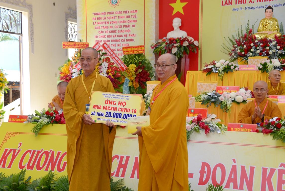 Thượng tọa Thích Nguyên Sĩ, tân Trưởng ban Trị sự GHPGVN quận 11 trao bảng biểu trưng 20 triệu đồng ủng hộ quỹ mua vắc-xin phòng chống Covid