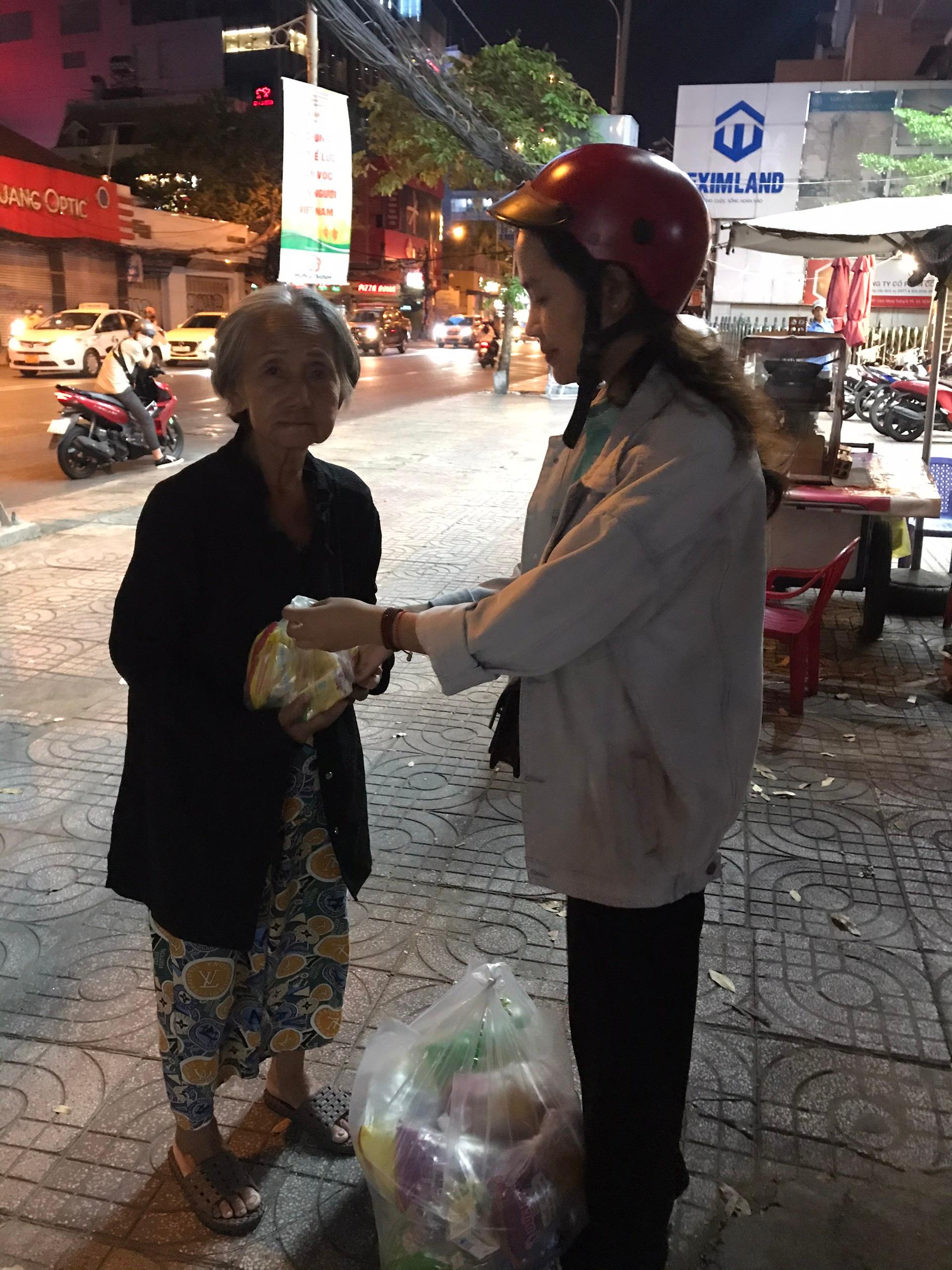 Thành viên nhóm thiện nguyện Bao Dung đang tặng quà cho một cụ già Thành viên nhóm thiện nguyện Bao Dung đang tặng quà cho một cụ già