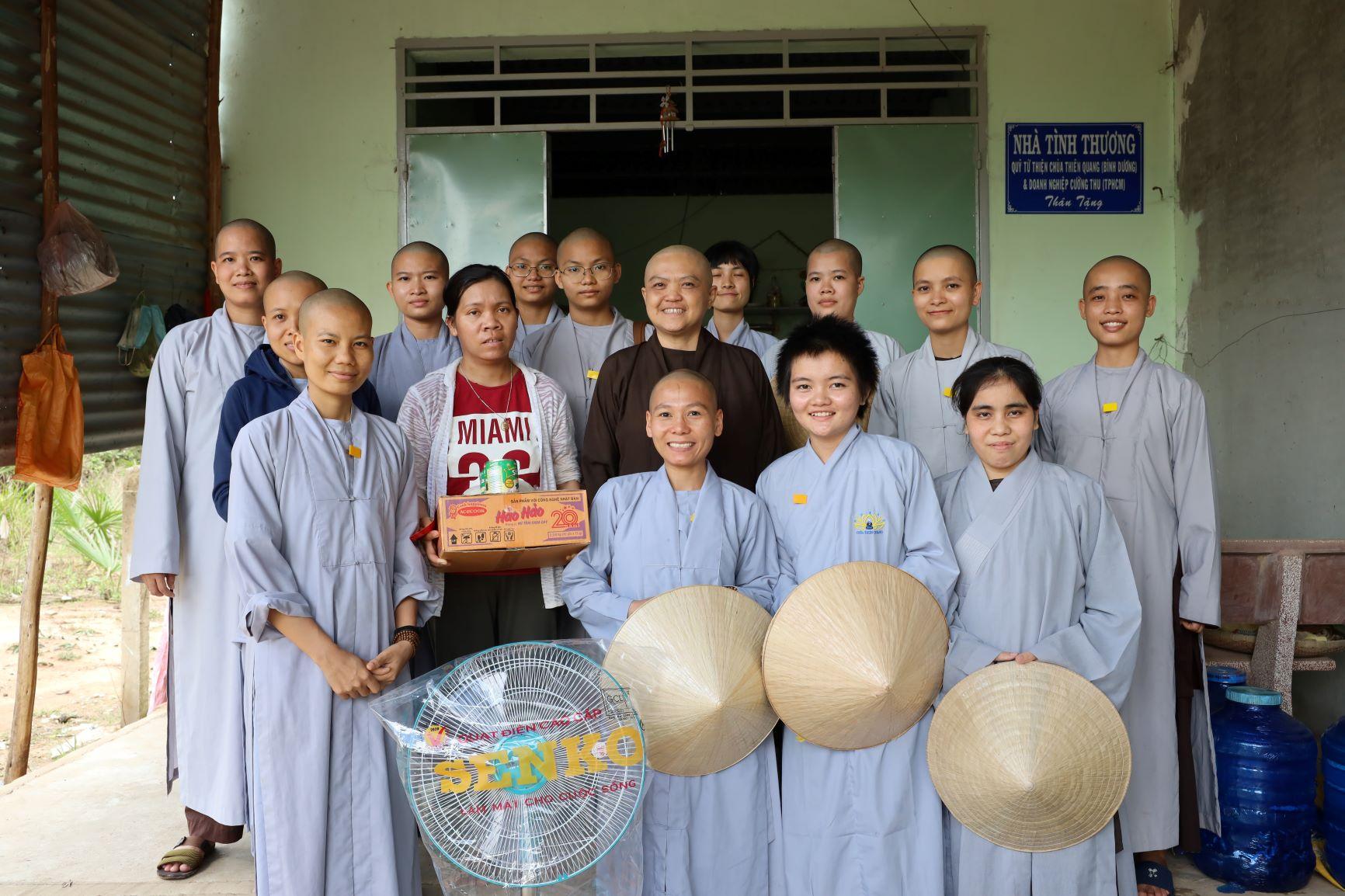 Đoàn từ thiện chùa Thiên Quang chụp ảnh lưu niệm với gia đình được nhận nhà tình thương đợt này